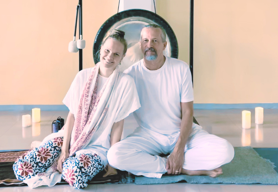 kaksi joogaopettajaa, mies ja nainen istuvat lattialla